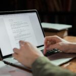 person writing on laptop
